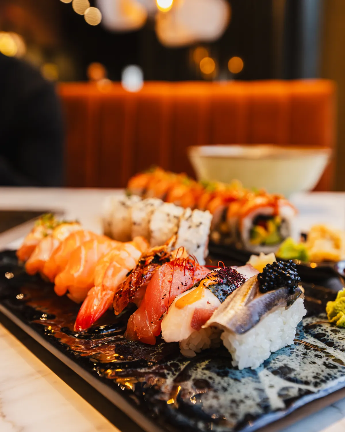 Nigiri och sushirullar på ett svart fat hos Tokyo Trio
